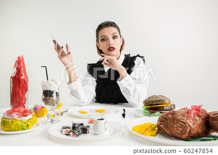 We are what we eat. Woman's eating plastic food, eco concept We are what we eat. Woman's eating plastic food, eco concept 60247854