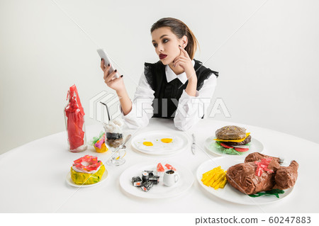 We are what we eat. Woman's eating plastic food, eco concept 60247883