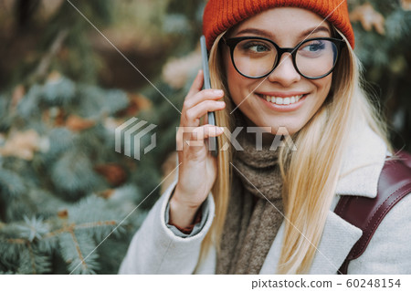 Young woman is talking on modern smartphone Young woman is talking on modern smartphone 60248154