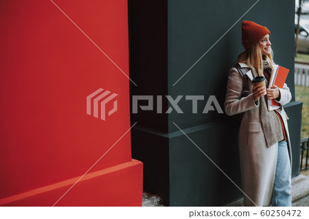 Pretty young woman with copybooks and coffee 60250472