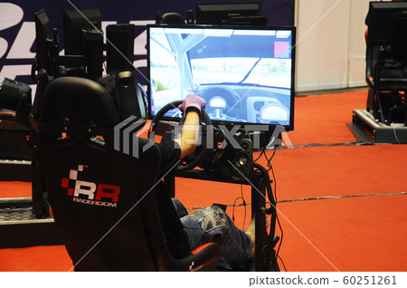 Simulation of race car video player game with big screen monitors and cockpit controls like a racing car. Simulation of race car video player game with big screen monitors and cockpit controls like a racing car. 60251261