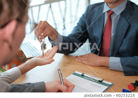 realtor agent give house key to couple customer. 60253228