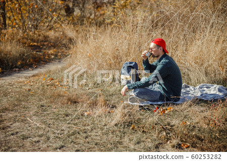 Calm man drinking tea at the picnic stock photo Calm man drinking tea at the picnic stock photo 60253282
