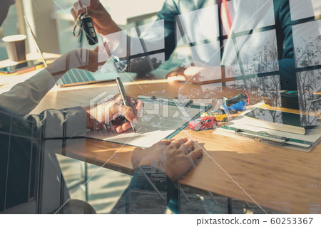 dealer salesman giving car key to owner. client 60253367