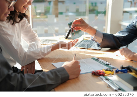 dealer salesman giving car key to owner. client 60253370