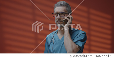 Male doctor having a phone call 60253612