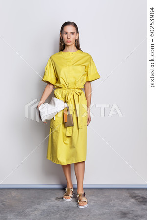 Cute fashion model in yellow dress with handbag Cute fashion model in yellow dress with handbag 60253984