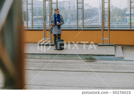 Handsome young man waiting for the tram on station Handsome young man waiting for the tram on station 60256028