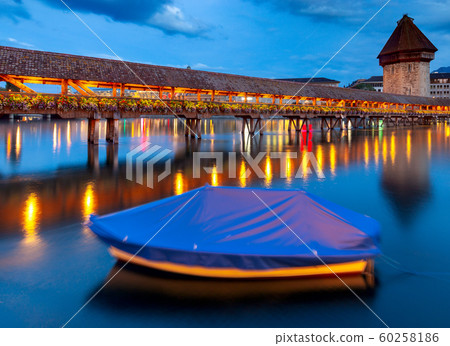 Lucerne. The famous Chapel, Kapellbrucke bridge at dawn in night lighting. 60258186