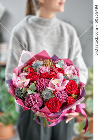 European floral shop. Beautiful bouquet of mixed flowers in womans hands. the work of the florist at a flower shop. Delivery fresh cut flower. European floral shop. Beautiful bouquet of mixed flowers in womans hands. the work of the florist at a flower shop. Delivery fresh cut flower. 60258494