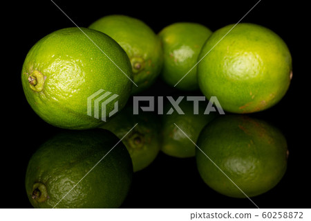Green sour lime isolated on black glass Green sour lime isolated on black glass 60258872