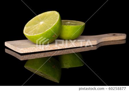 Green sour lime isolated on black glass 60258877