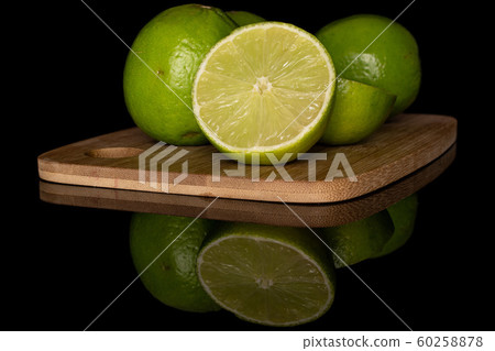 Green sour lime isolated on black glass 60258878