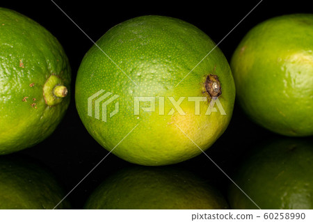 Green sour lime isolated on black glass Green sour lime isolated on black glass 60258990