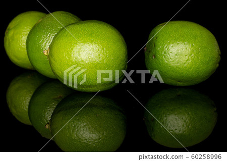 Green sour lime isolated on black glass 60258996