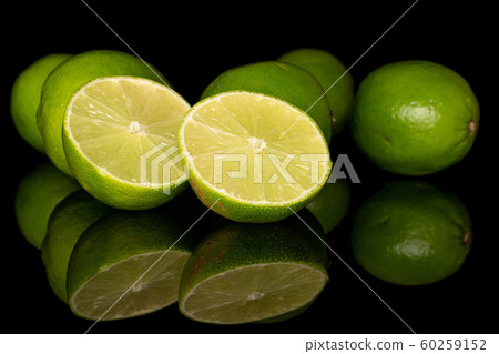 Green sour lime isolated on black glass Green sour lime isolated on black glass 60259152