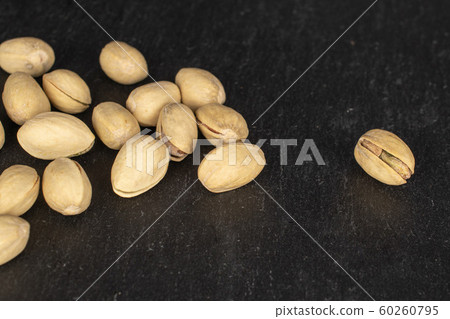 Salted pistachio on grey stone Salted pistachio on grey stone 60260795