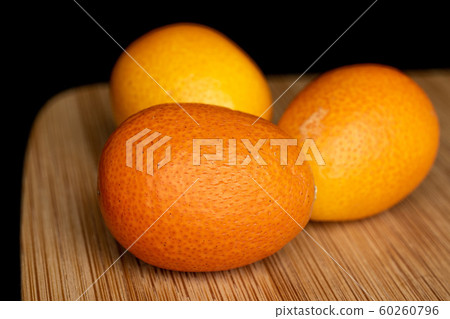 Tasty orange kumquat isolated on black glass Tasty orange kumquat isolated on black glass 60260796