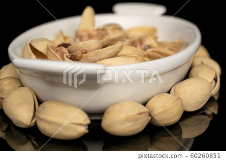 Salted pistachio isolated on black glass Salted pistachio isolated on black glass 60260851