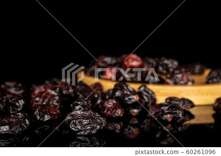 Dried cowberry isolated on black glass Dried cowberry isolated on black glass 60261096