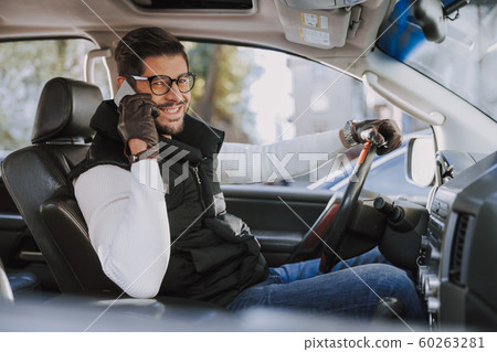 Handsome Caucasian man in leather gloves driving his new car Handsome Caucasian man in leather gloves driving his new car 60263281