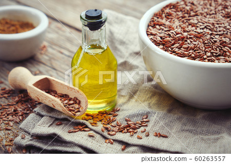 Mortar of flax seeds and bottle of linseed oil. Mortar of flax seeds and bottle of linseed oil. 60263557