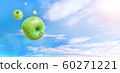 在藍色的天空和雲彩飛翔的多個綠色蘋果 60271221