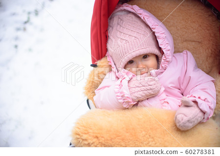 Cute baby in stroller on frosty winter day. Baby Cute baby in stroller on frosty winter day. Baby 60278381
