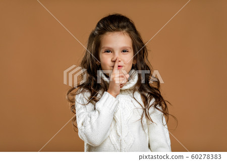 beautiful curly little girl in white sweater asking to be quiet beautiful curly little girl in white sweater asking to be quiet 60278383