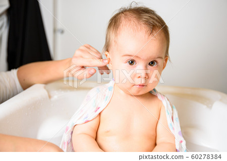 Adorable baby girl taking a bath by mother at Adorable baby girl taking a bath by mother at 60278384