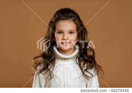 little girl in white sweater looking to camera 60278388