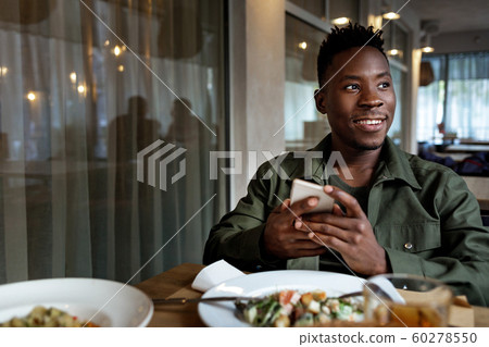 young african american man using laptop in cafe young african american man using laptop in cafe 60278550