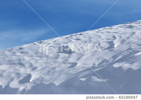 Off-piste snowy slope at windy winter evening Off-piste snowy slope at windy winter evening 60280097