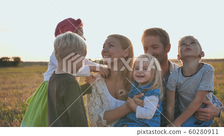 A family of 6 people against the backdrop of a gentle sunset. 60280911