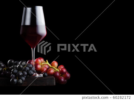 Elegant glass of red wine with dark and red grapes Elegant glass of red wine with dark and red grapes 60282172