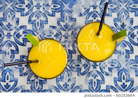 Fresh mango smoothie, juice on blue background. Top view. Fresh mango smoothie, juice on blue background. Top view. 60283664