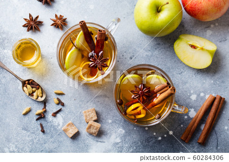 Apple mulled cider with spices in glass cup. Grey stone background. Top view. 60284306