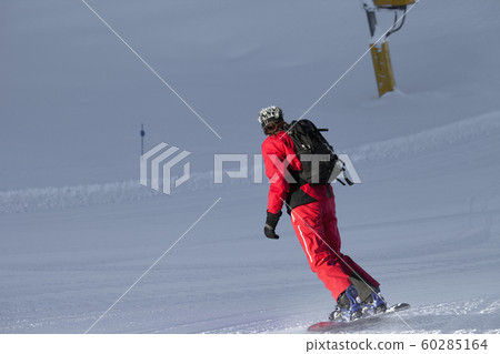 Snowboarder on snowy ski slope at winter evening 60285164