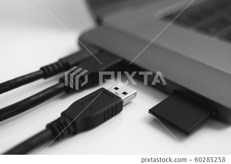 Laptop with USB Type-C adapter with pluged USB cables and SD card. The USB adapter under the Type-C connector for laptop. Multiport station for laptop with multiple different ports. Hub Converter. 60285258