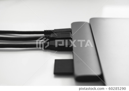 Laptop with USB Type-C adapter with pluged USB cables and SD card. The USB adapter under the Type-C connector for laptop. Multiport station for laptop with multiple different ports. Hub Converter. 60285290