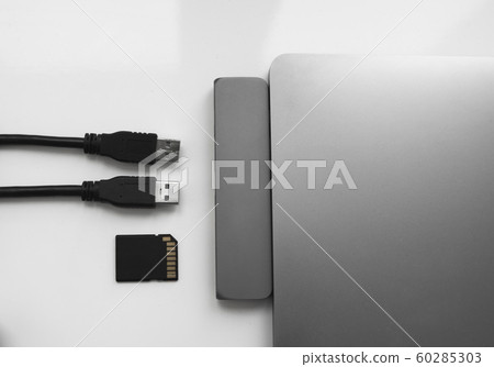 Laptop with USB Type-C adapter with pluged USB cables and SD card. The USB adapter under the Type-C connector for laptop. Multiport station for laptop with multiple different ports. Hub Converter. 60285303