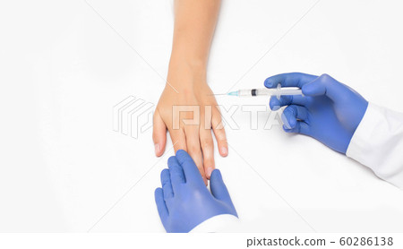Doctor makes sclerotherapy injection into the arm of the girl's patient for the disappearance of swollen veins, white background, copy space, treatment 60286138