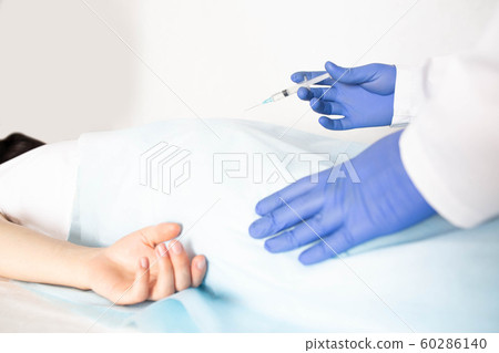 Doctor proctologist treats a patient for hemorrhoids with the help of modern method sclerotherapy, white background, copy space, painlessness 60286140