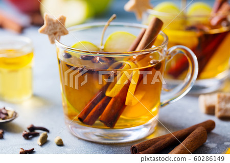 Apple mulled cider with spices in glass cup. Grey stone background. Close up. 60286149