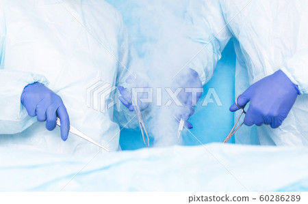 Two surgeons of Hiurge do surgery using liquid nitrogen cryotherapy to remove malignant tumors, tumors. Modern method of treatment cryosurgery, hemorrhoids 60286289