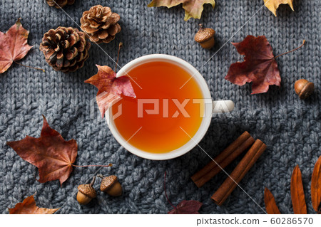 Tea cup with autumn leaves. Grey background. Top view. 60286570
