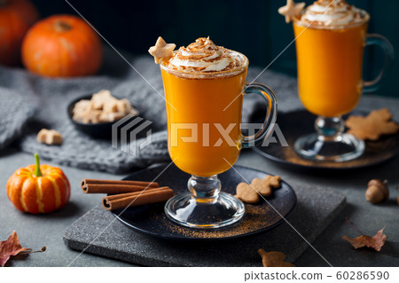 Pumpkin latte with spices. Boozy cocktail with whipped cream on slate board. Grey background. Close up. 60286590
