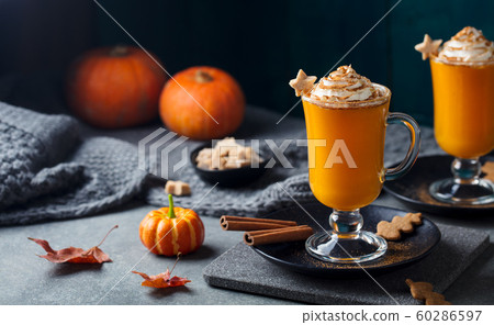 Pumpkin latte with spices. Boozy cocktail with whipped cream on slate board. Grey background. Copy space. Pumpkin latte with spices. Boozy cocktail with whipped cream on slate board. Grey background. Copy space. 60286597