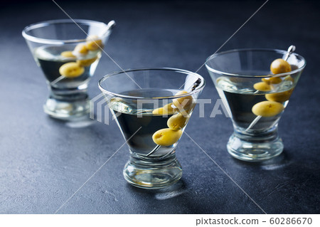 Martini cocktail with green olives. Slate background. Close up. Martini cocktail with green olives. Slate background. Close up. 60286670