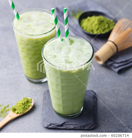 Matcha green tea ice latte with matcha powder and bamboo whisk. Grey background. Close up. 60286714